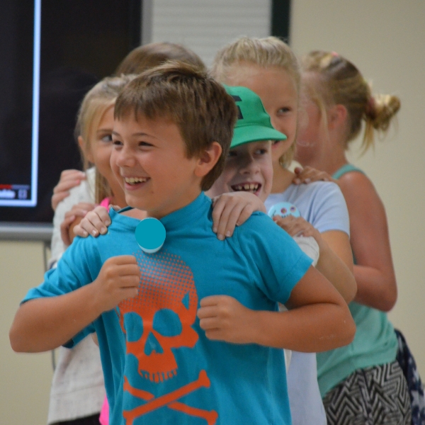 Smiling children play follow-the-leader game