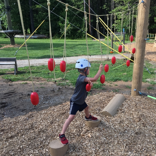 Child walks across Kids course logs