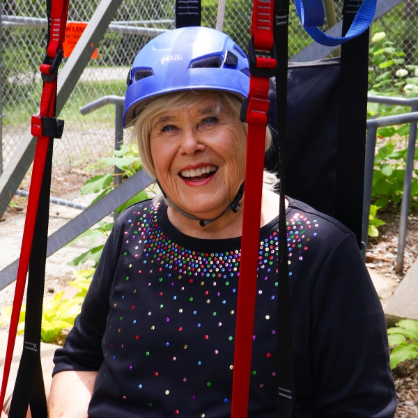 Woman in adaptable zip harness smiles