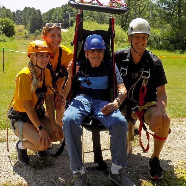 Smiling veteran sits in accessible zip harness